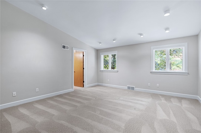 carpeted spare room with lofted ceiling and a wealth of natural light