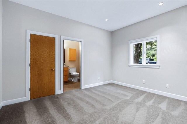 unfurnished bedroom with light colored carpet and ensuite bath