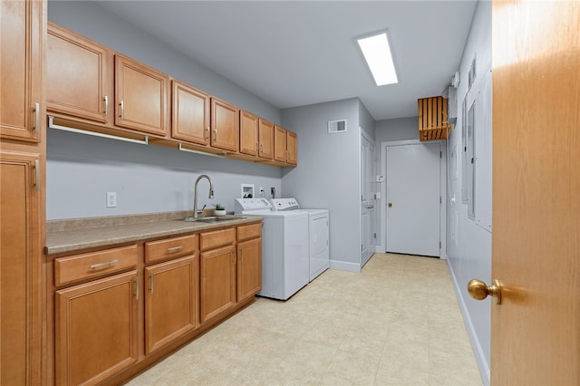 laundry area featuring cabinets, light tile patterned floors, washing machine and clothes dryer, and sink