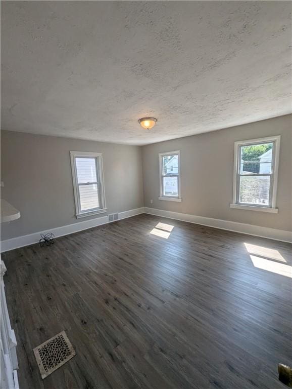 empty room featuring dark hardwood / wood-style flooring and a textured ceiling