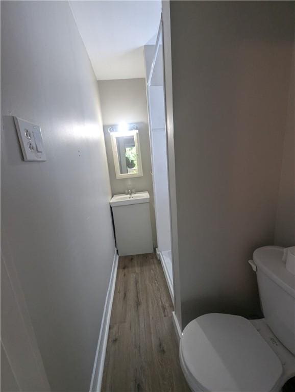 bathroom with vanity, toilet, and hardwood / wood-style floors