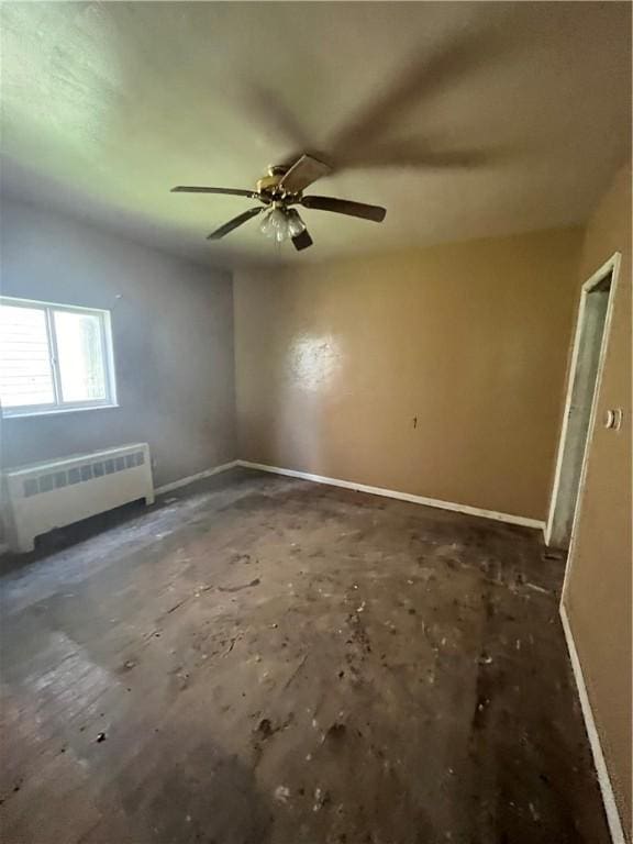 unfurnished room with ceiling fan and radiator