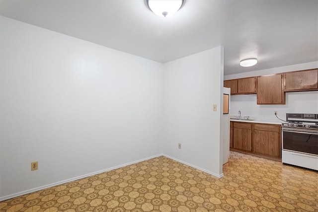 kitchen featuring sink, range, and light tile patterned floors