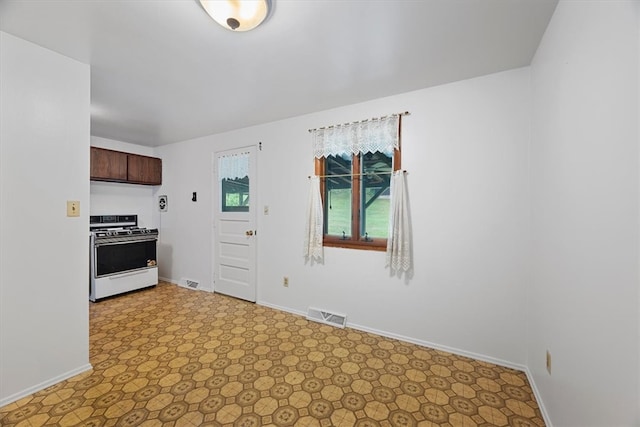 kitchen with range, light tile patterned flooring, and dark brown cabinets