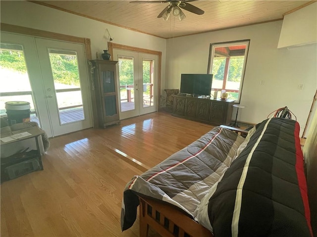 living area with ceiling fan, wood finished floors, ornamental molding, and french doors