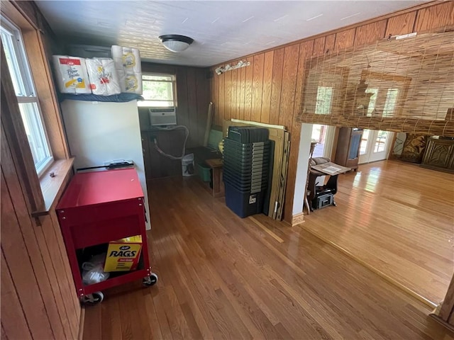 recreation room with cooling unit, wooden walls, and wood finished floors