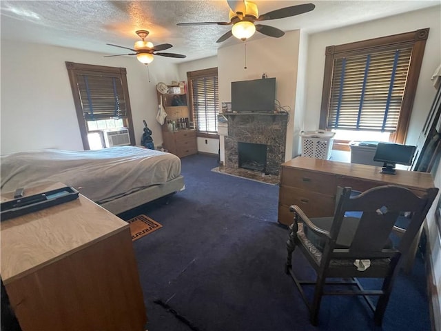 bedroom featuring a textured ceiling, cooling unit, ceiling fan, a fireplace, and dark colored carpet