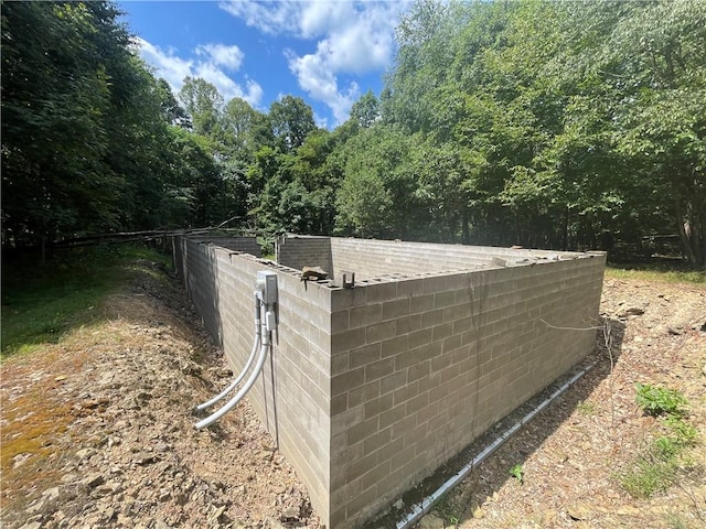 exterior space featuring fence and concrete block siding