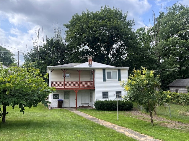 view of property featuring a balcony and a front lawn