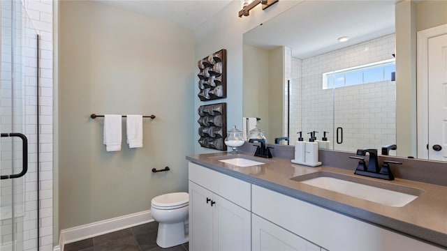 bathroom with tile patterned floors, toilet, a shower with door, and dual bowl vanity