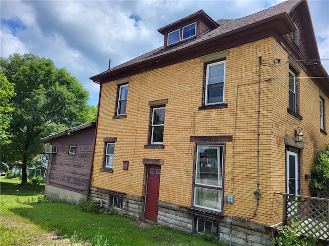 view of side of home with a yard