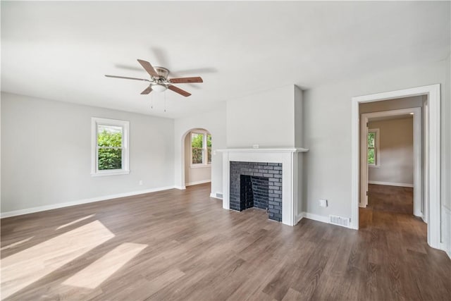 unfurnished living room featuring ceiling fan, dark hardwood / wood-style floors, and a fireplace