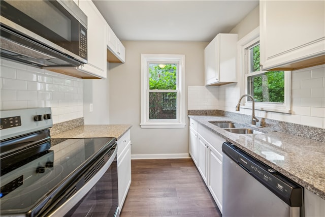 kitchen with dark hardwood / wood-style flooring, appliances with stainless steel finishes, tasteful backsplash, and white cabinetry