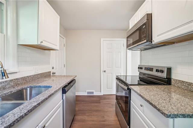 kitchen featuring decorative backsplash, stainless steel appliances, white cabinetry, and dark wood-type flooring