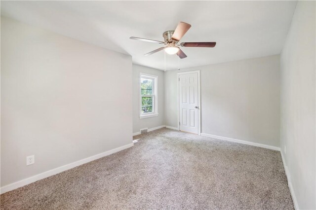 carpeted spare room with ceiling fan