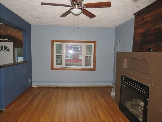 unfurnished living room with a textured ceiling, wood-type flooring, and ceiling fan