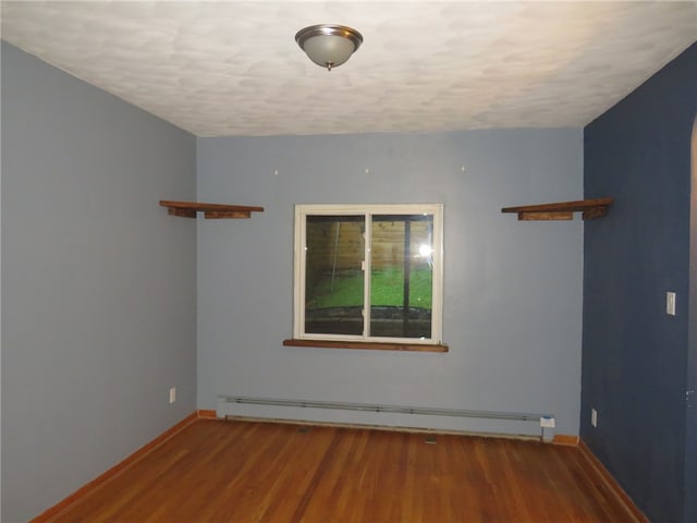 empty room with a textured ceiling, hardwood / wood-style floors, and a baseboard radiator