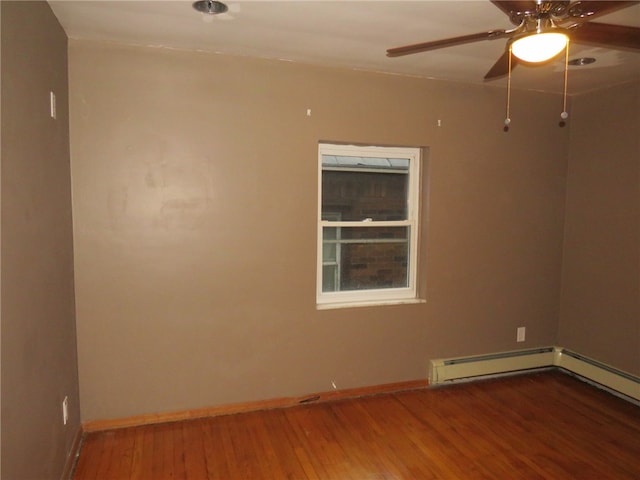 empty room featuring baseboard heating, hardwood / wood-style floors, and ceiling fan