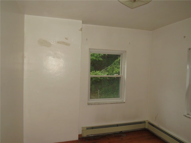 spare room featuring hardwood / wood-style flooring and baseboard heating