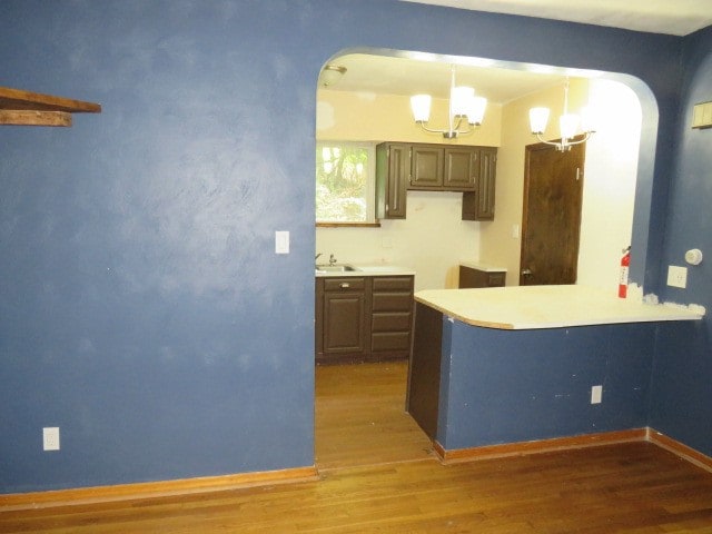 kitchen featuring a chandelier, hardwood / wood-style floors, decorative light fixtures, and sink