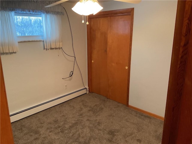 interior space featuring ceiling fan, baseboard heating, and carpet