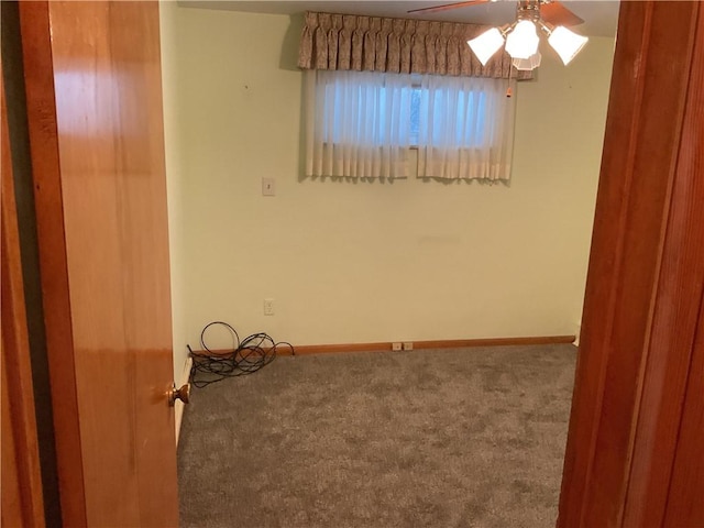 carpeted spare room featuring ceiling fan