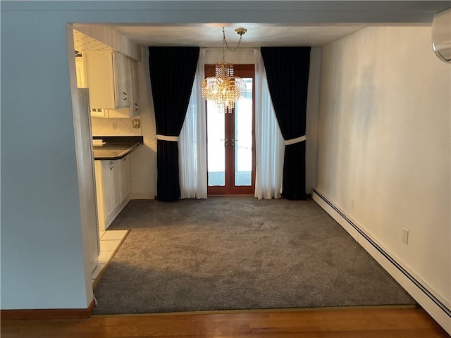 unfurnished dining area with french doors, a baseboard heating unit, light carpet, and a notable chandelier