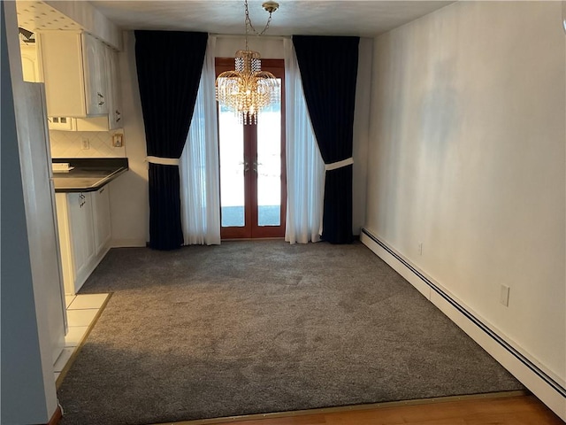 unfurnished dining area featuring a notable chandelier, baseboard heating, french doors, and light colored carpet