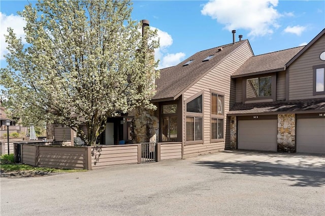 M1 Sunridge Rd, Seven Springs Resort, PA 15622 - view of front of home with driveway, stone siding, a shingled roof, and an attached garage
