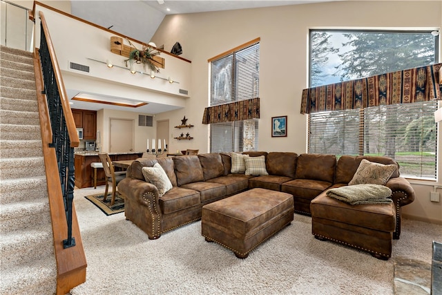 carpeted living room featuring high vaulted ceiling