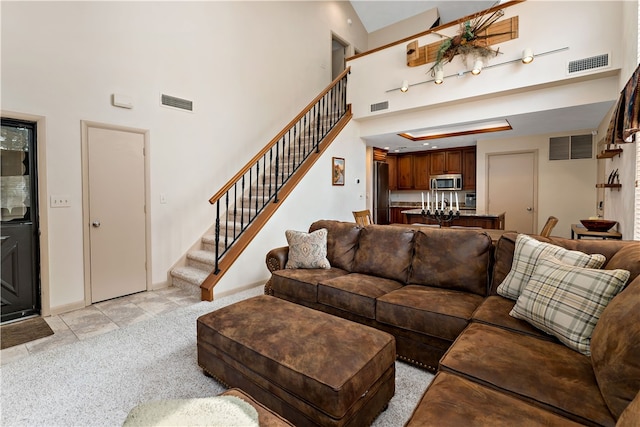 carpeted living room featuring a high ceiling