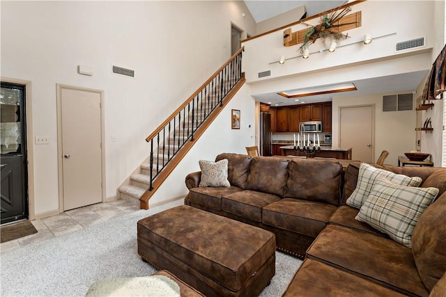 M1 Sunridge Rd, Seven Springs Resort, PA 15622 - living room featuring stairs, light carpet, light tile patterned flooring, a high ceiling, and baseboards
