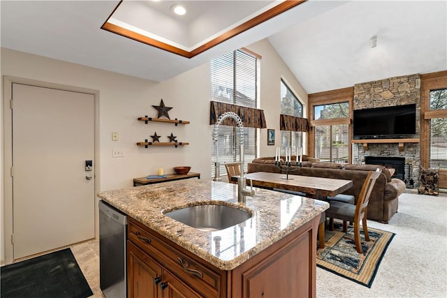 M1 Sunridge Rd, Seven Springs Resort, PA 15622 - kitchen with stainless steel dishwasher, brown cabinetry, a stone fireplace, a sink, and light stone countertops