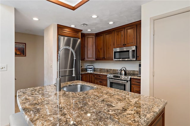 M1 Sunridge Rd, Seven Springs Resort, PA 15622 - kitchen featuring appliances with stainless steel finishes, dark stone countertops, recessed lighting, an island with sink, and a sink