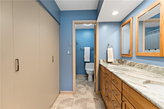 bathroom featuring tile patterned flooring, double sink vanity, and toilet