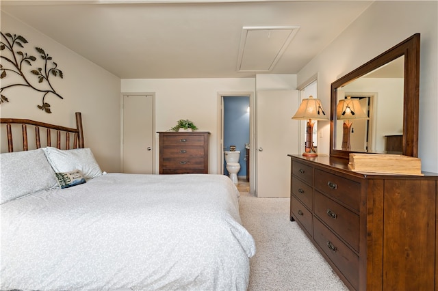 bedroom featuring connected bathroom and light colored carpet