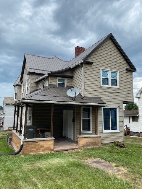 back of house with a lawn and a patio