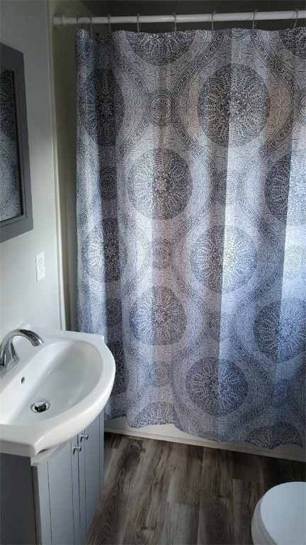 bathroom with toilet, vanity, hardwood / wood-style floors, and a shower with shower curtain