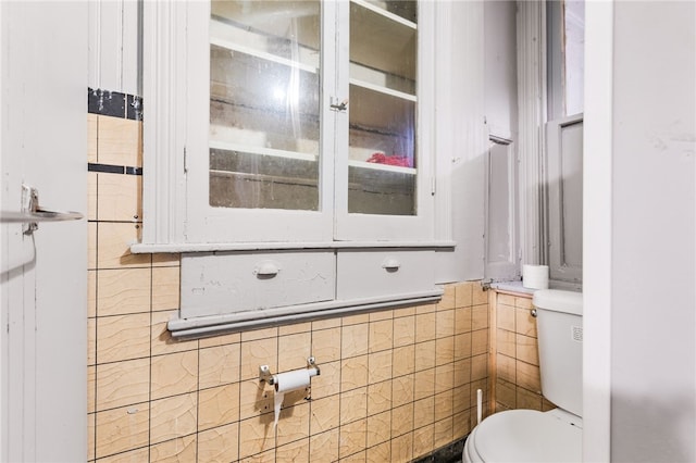 bathroom with tile walls and toilet