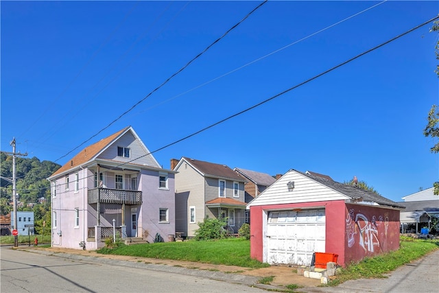 view of front of home with a balcony, an outdoor structure, and a garage