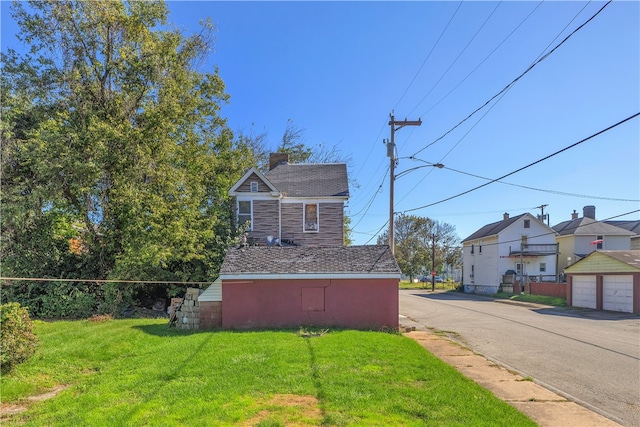 view of side of property featuring a lawn and a garage