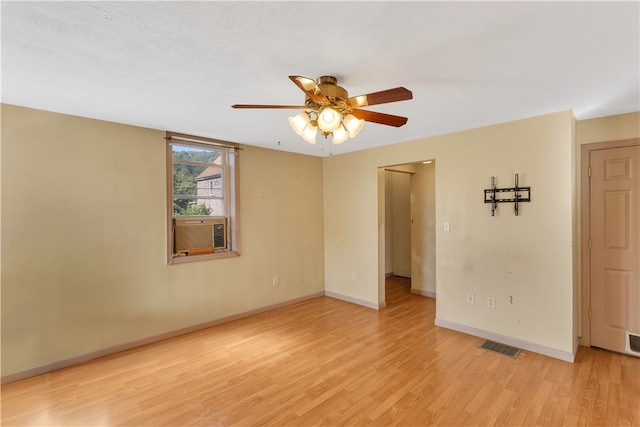 spare room featuring ceiling fan, cooling unit, a textured ceiling, and light hardwood / wood-style flooring