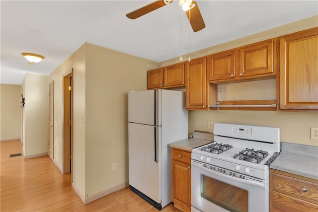 kitchen with light hardwood / wood-style flooring, white appliances, and ceiling fan