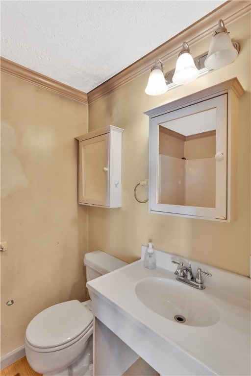 bathroom with vanity, a textured ceiling, crown molding, and toilet