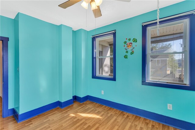 empty room with ceiling fan and hardwood / wood-style flooring