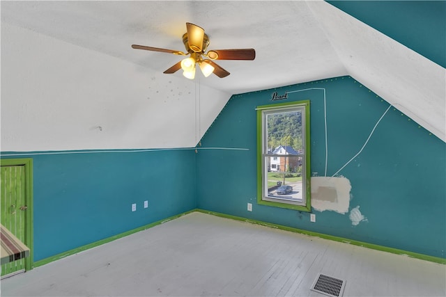 bonus room with a textured ceiling, light hardwood / wood-style floors, vaulted ceiling, and ceiling fan