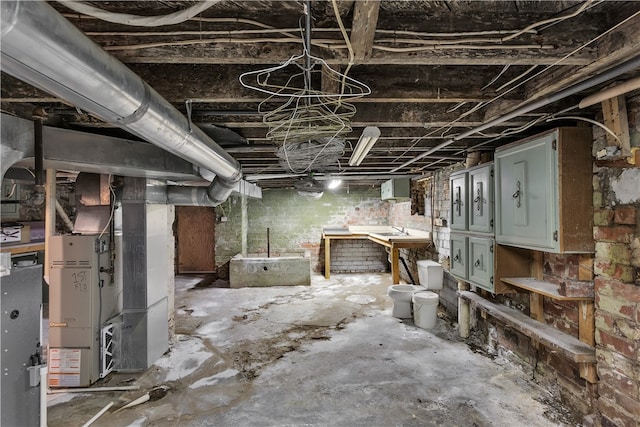 basement featuring brick wall and heating unit