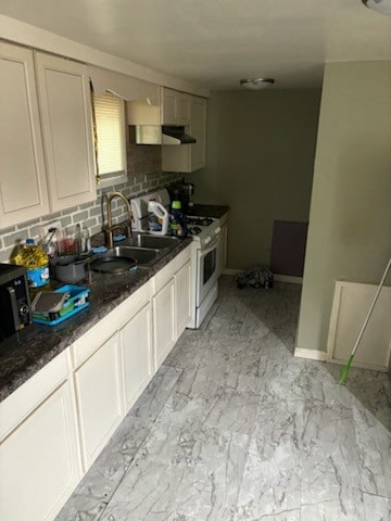 kitchen featuring range with gas stovetop, light tile patterned floors, decorative backsplash, and sink