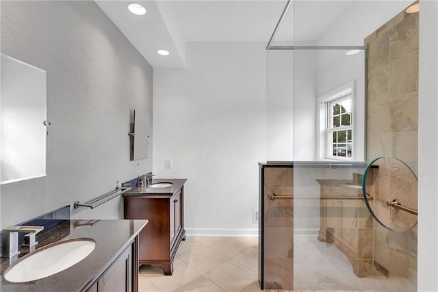 full bathroom featuring walk in shower, two vanities, a sink, and recessed lighting