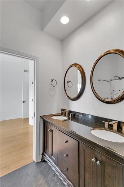 full bathroom with double vanity, a sink, and tile patterned floors